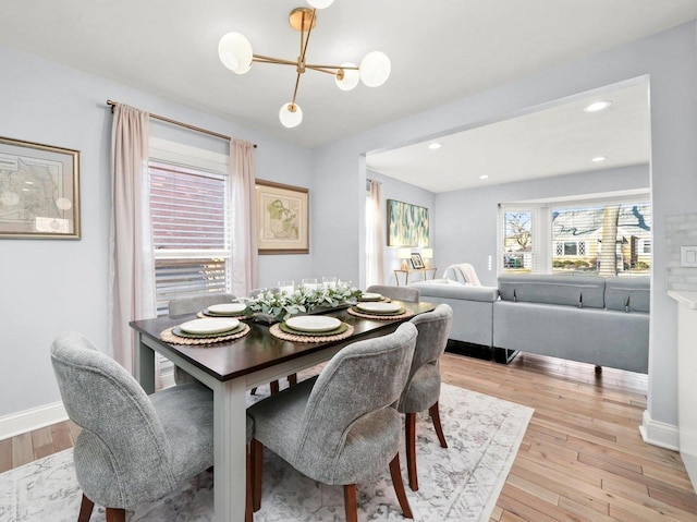 dining area with a chandelier, recessed lighting, light wood-type flooring, and baseboards