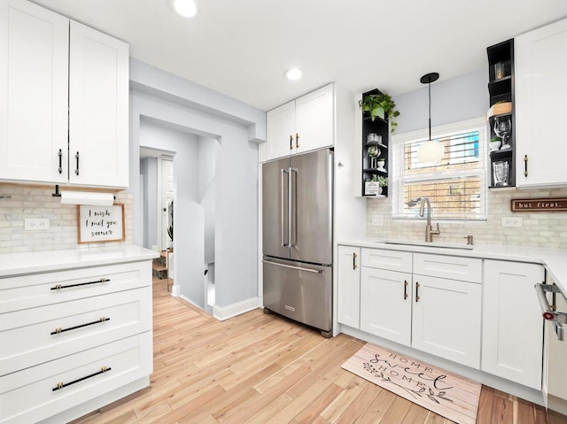 kitchen with light wood-type flooring, open shelves, a sink, white cabinetry, and high quality fridge