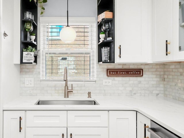 kitchen featuring open shelves, white cabinetry, backsplash, and a sink