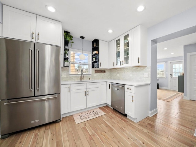 kitchen with light countertops, light wood finished floors, appliances with stainless steel finishes, and a sink