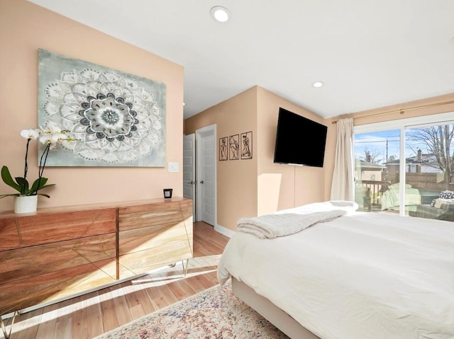 bedroom with access to exterior, recessed lighting, light wood-type flooring, and baseboards