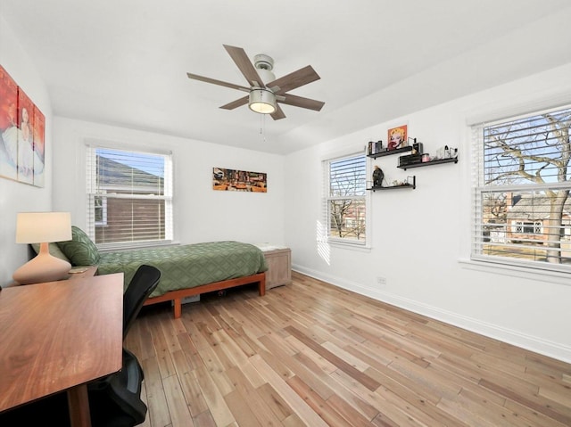 bedroom featuring baseboards, ceiling fan, and light wood finished floors