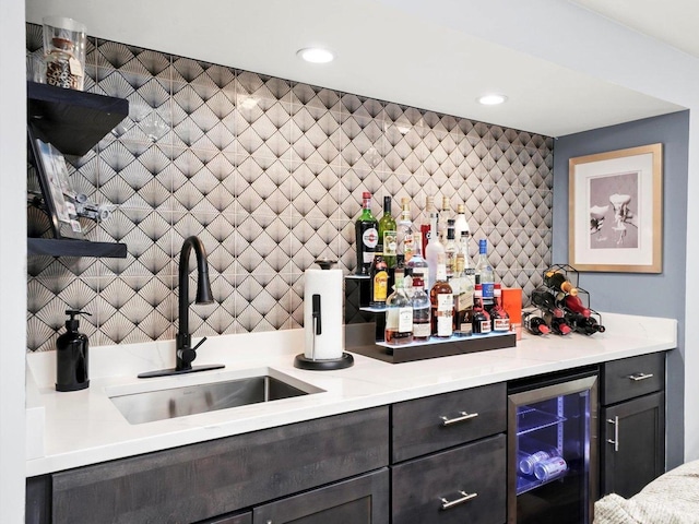 bar featuring wine cooler, decorative backsplash, a dry bar, and a sink