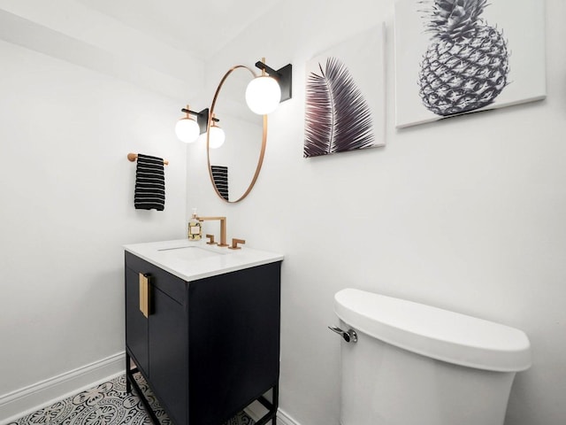 half bathroom with toilet, vanity, and baseboards