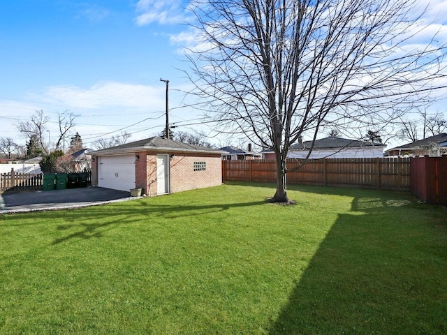 view of yard featuring an outbuilding, a fenced backyard, and a garage