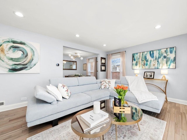 living room with visible vents, recessed lighting, baseboards, and wood finished floors