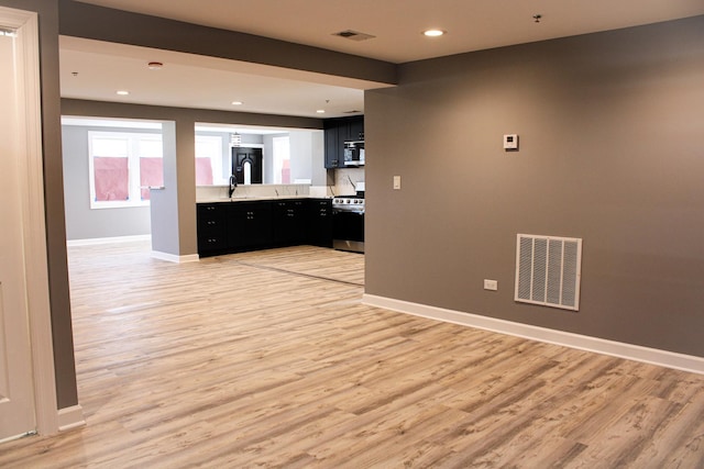 kitchen featuring light wood-type flooring, appliances with stainless steel finishes, visible vents, and dark cabinets