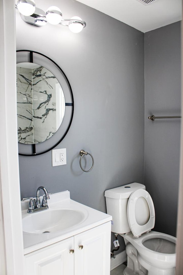 half bathroom featuring toilet and vanity