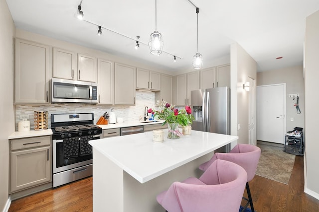 kitchen with tasteful backsplash, a breakfast bar area, appliances with stainless steel finishes, and wood finished floors