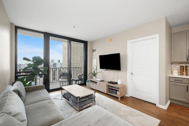 living area with dark wood-style floors, a wall of windows, bar area, and baseboards