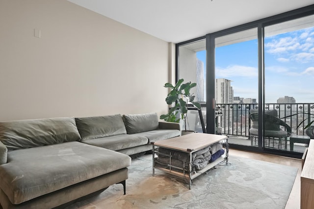 living room featuring a view of city, expansive windows, and wood finished floors