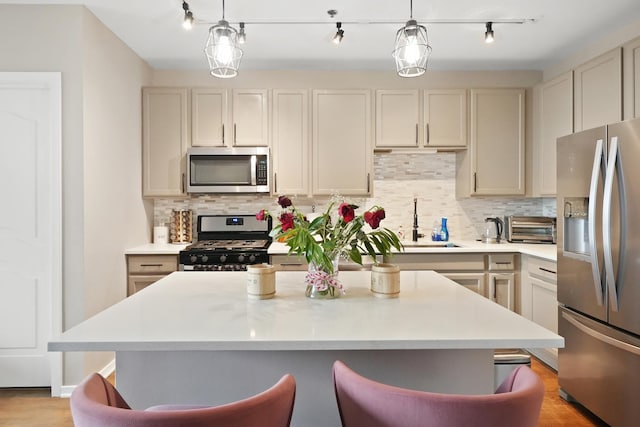 kitchen with stainless steel appliances, light countertops, a sink, and a breakfast bar area