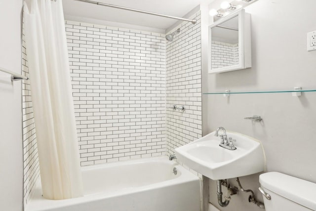 bathroom featuring toilet, a sink, and shower / tub combo with curtain