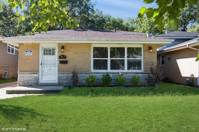 view of front of property featuring a front yard, stone siding, and brick siding