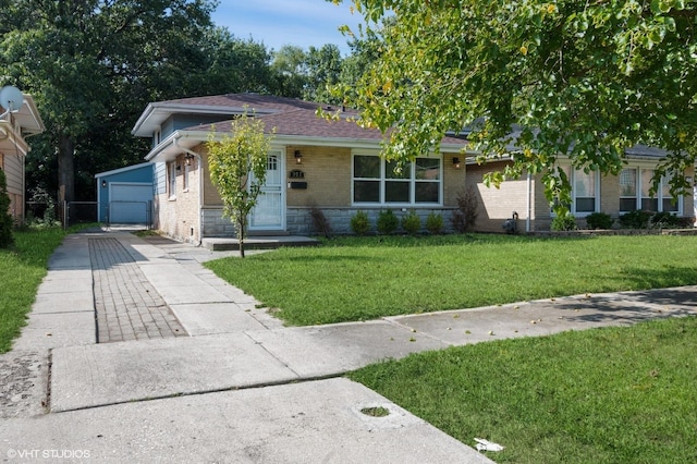 view of front of home featuring concrete driveway, brick siding, a front lawn, and an outdoor structure