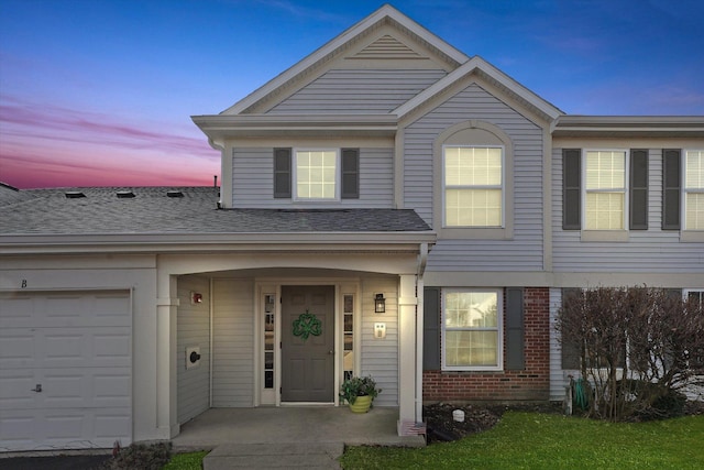 view of front of property featuring brick siding, roof with shingles, and an attached garage