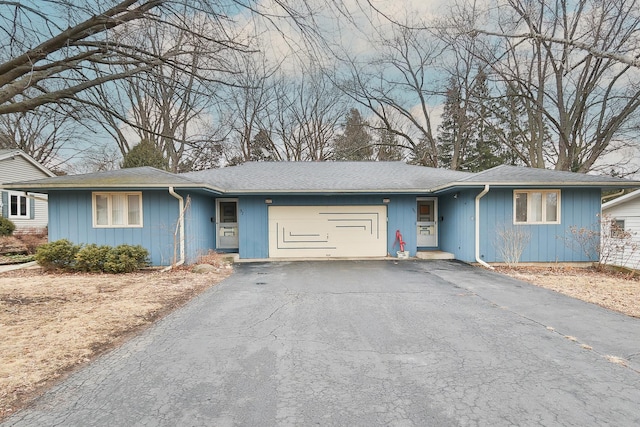 single story home with driveway and an attached garage