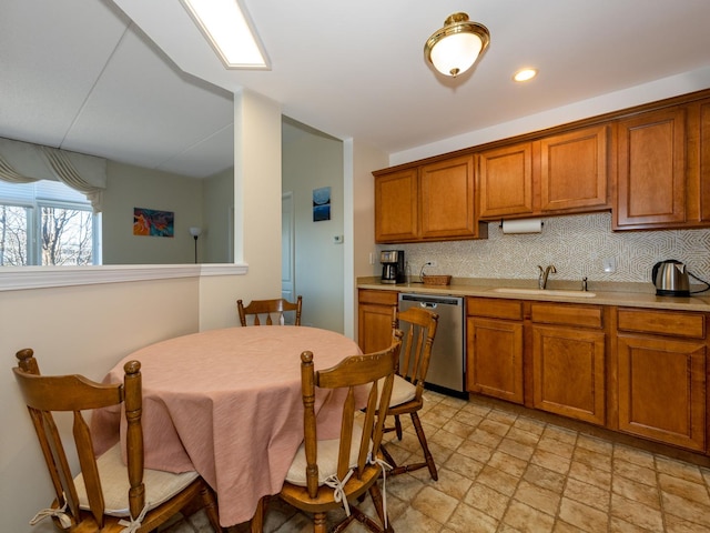 kitchen with a sink, decorative backsplash, brown cabinetry, and stainless steel dishwasher