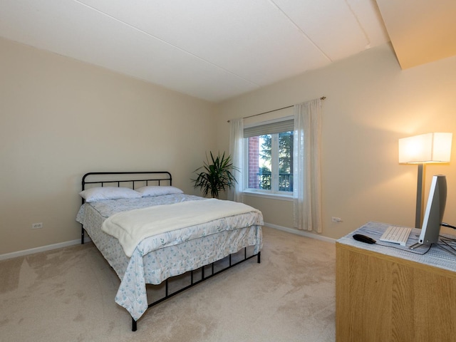 bedroom featuring light carpet and baseboards