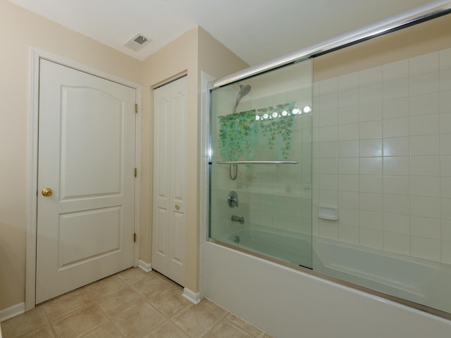 bathroom featuring tile patterned flooring, visible vents, and bath / shower combo with glass door