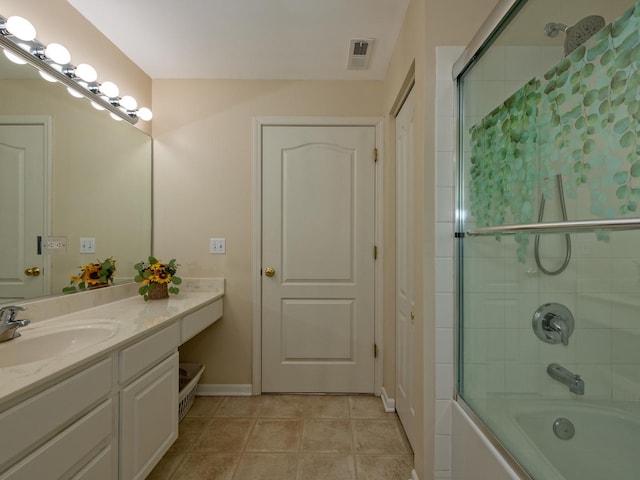 bathroom featuring visible vents, baseboards, enclosed tub / shower combo, tile patterned flooring, and vanity