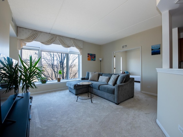 carpeted living area featuring baseboards and visible vents