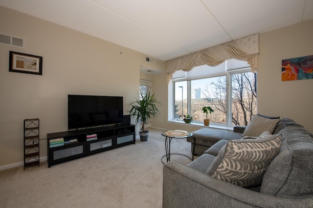 living area featuring carpet floors, visible vents, and baseboards