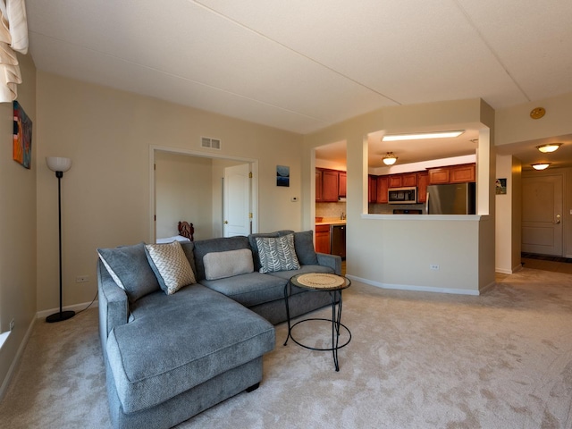 living room featuring light colored carpet, visible vents, and baseboards