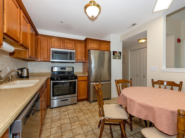 kitchen with stainless steel appliances, a sink, and light countertops