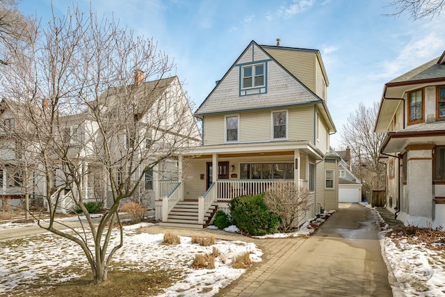 traditional style home featuring a garage, covered porch, and an outdoor structure