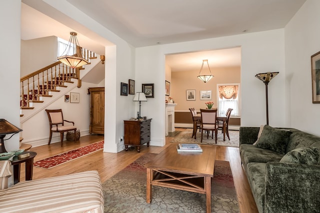 living area with stairs, baseboards, and wood finished floors