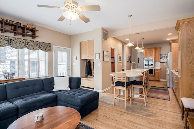 living area featuring light wood finished floors, recessed lighting, visible vents, a ceiling fan, and baseboards