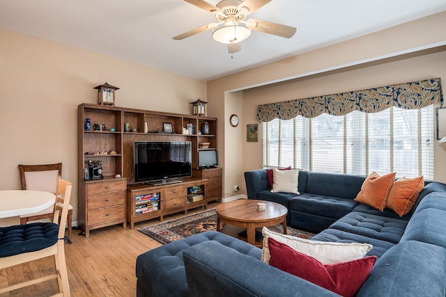 living room with light wood-type flooring, a ceiling fan, and baseboards