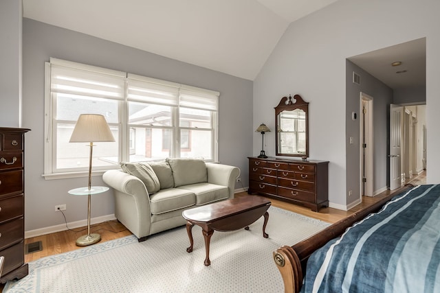 bedroom featuring light wood-style floors, multiple windows, vaulted ceiling, and baseboards