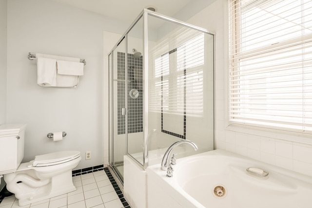 bathroom featuring a stall shower, a garden tub, toilet, and tile patterned floors