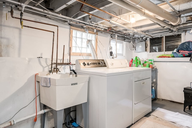 washroom with laundry area, electric panel, separate washer and dryer, and a sink