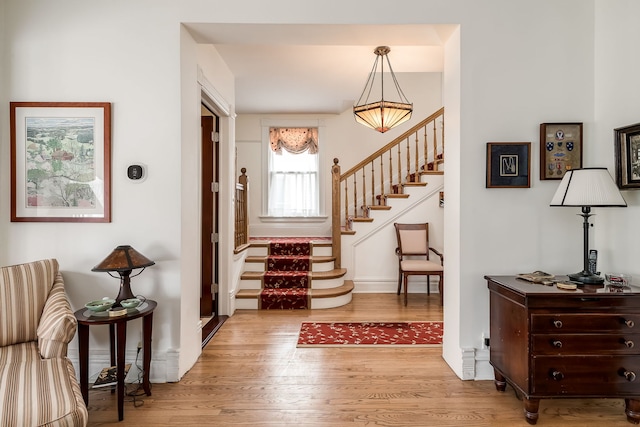 entrance foyer featuring wood finished floors, baseboards, and stairs