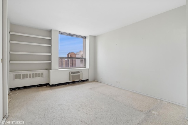 empty room featuring carpet floors, a wall mounted air conditioner, a city view, and radiator heating unit