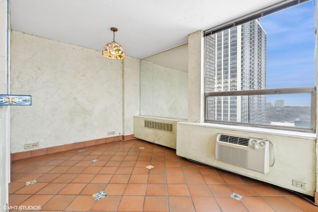 kitchen featuring tile patterned flooring, a city view, decorative light fixtures, and radiator heating unit