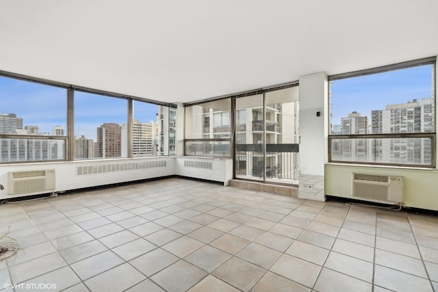 empty room with tile patterned flooring, a wall mounted air conditioner, a city view, and a wall unit AC