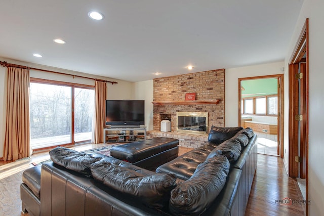 living area featuring a fireplace, wood finished floors, and recessed lighting