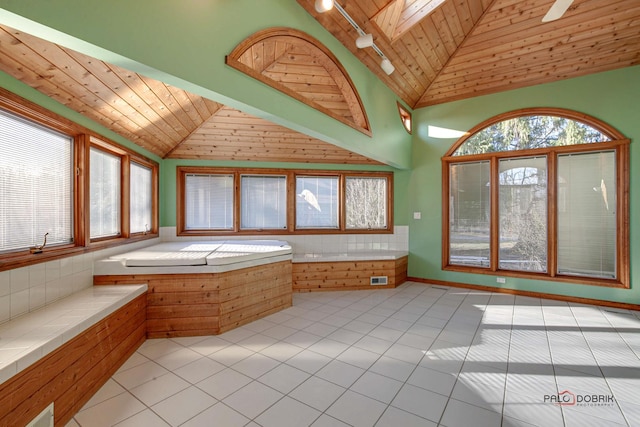 bathroom featuring vaulted ceiling with skylight, wood ceiling, track lighting, and tile patterned floors