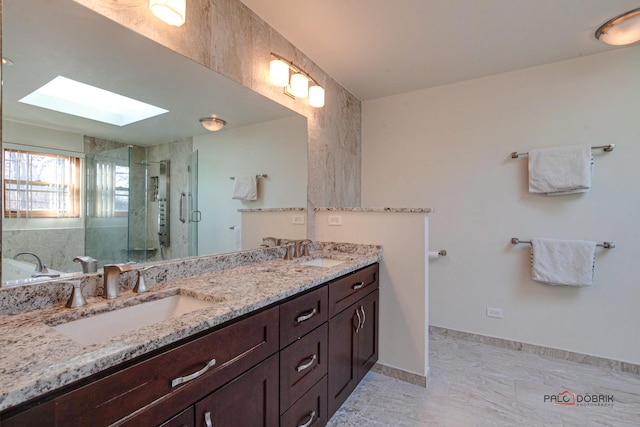 full bath with double vanity, a skylight, a sink, and a stall shower