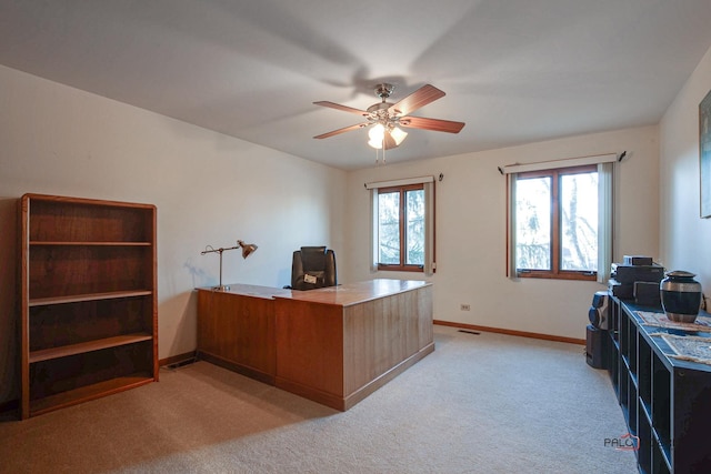 home office featuring light carpet, ceiling fan, and baseboards