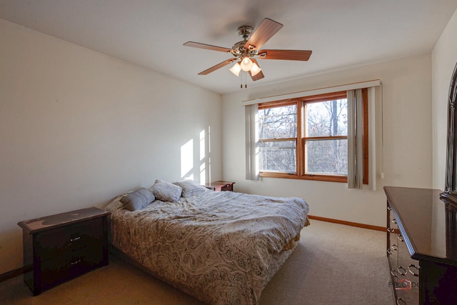 carpeted bedroom with ceiling fan and baseboards