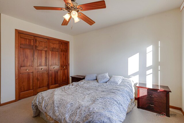 carpeted bedroom with a ceiling fan, baseboards, and a closet