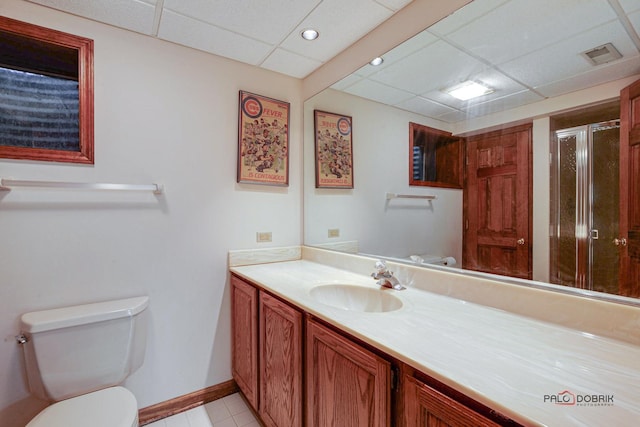 bathroom featuring a paneled ceiling, toilet, visible vents, vanity, and a shower stall