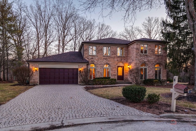 view of front of property featuring decorative driveway, brick siding, an attached garage, and roof with shingles