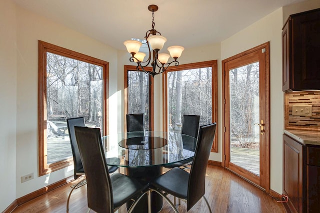 dining room featuring a notable chandelier, baseboards, and wood finished floors