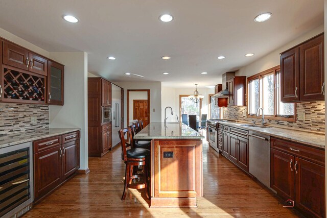 kitchen featuring beverage cooler, appliances with stainless steel finishes, dark wood finished floors, and a sink